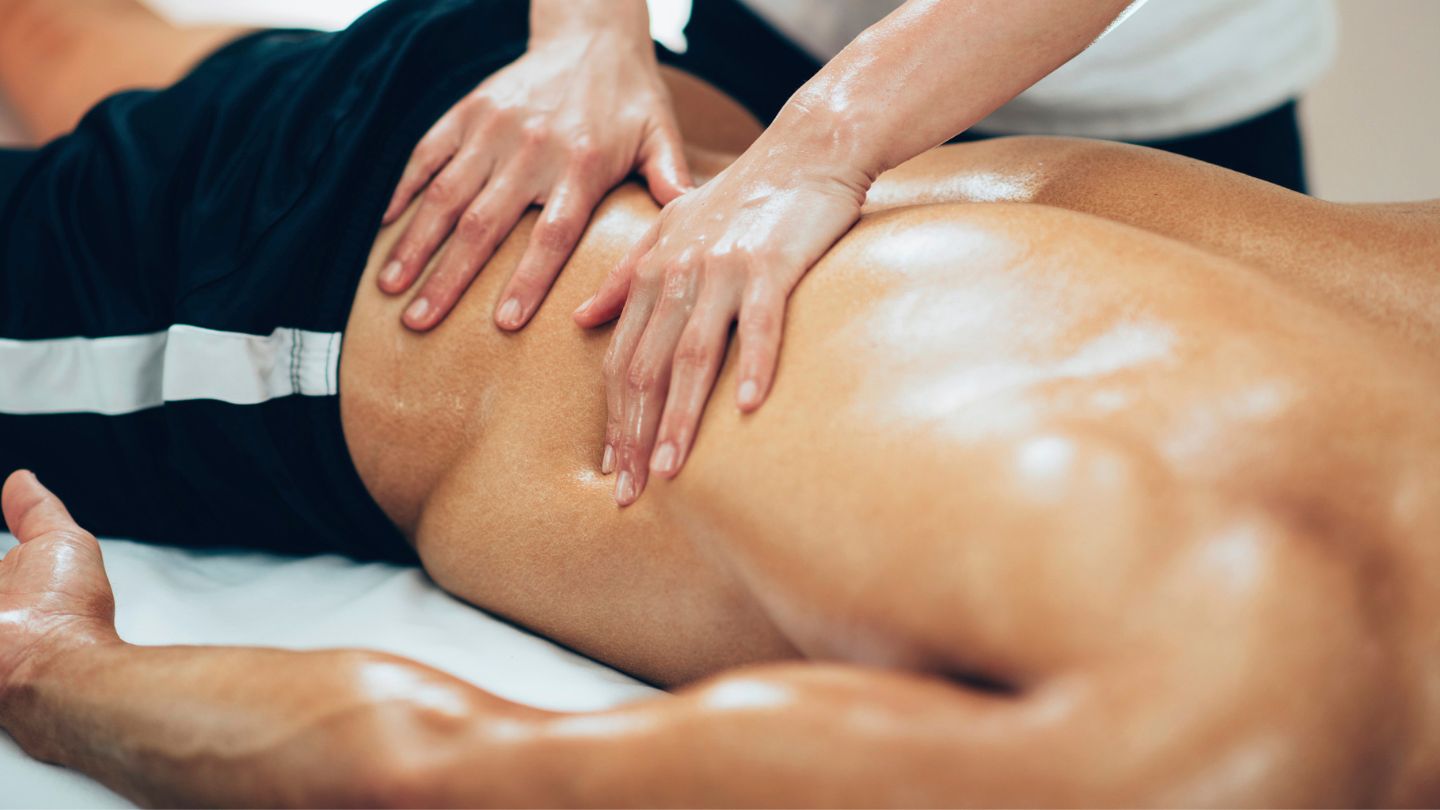 Athlete receiving a sports massage with a focus on the lower back for enhanced performance and flexibility.